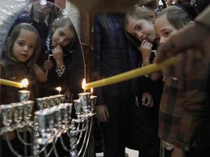 Ultra-Orthodox Jewish Krois family light candles on the first night of the Jewish holiday of Hanukkah in the Ultra-Orthodox Mea Shearim neighbourhood of Jerusalem on December 22, 2019. The holiday commemorates the rededication of the holy temple in Jerusalem after Jewish victory in 165 BC over the Hellenistic Seleucid armies of Antiochus IV Epiphanies, who had outlawed Jewish rituals and ordered Jews to worship Greek gods and adopt their customs. MENAHEM KAHANA / AFP