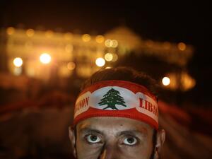 A Lebanese anti-corruption protester, his forehead wrapped with the national flag, poses in front of the Grand Serail (government building) during a protest in downtown Beirut on December 22, 2019. Demonstrators are demanding an overhaul of the political establishment which they deem corrupt and inept, insisting on a government of independents and experts with no ties to the country's sectarian parties. PATRICK BAZ / AFP