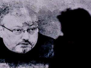 In this file photo taken on November 11, 2018 a man passes in front of a screen showing Jamal Khashoggi during a commemoration event of Khashoggi's supporters in Istanbul. Five people were sentenced to death on December 23, 2019, over Saudi journalist Jamal Khashoggi's murder, but two top aides to the powerful crown prince were exonerated as authorities said the killing was not premeditated. OZAN KOSE / AFP