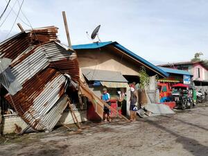 Residents stand next to a house damaged by typhoon Phanfone in Ormoc City, Leyte province in central Philippines on December 25, 2019. Typhoon Phanfone pummelled the central Philippines on December 25, bringing a wet, miserable and terrifying holiday season to millions in the mainly Catholic nation. RONALD FRANK DEJON / AFP