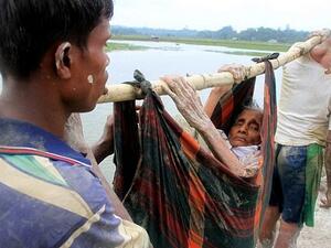 Rohingya refugees carry an elderly woman from Rakhine state in Myanmar along a path near Teknaf in Bangladesh on September 3, 2017. (AFP PHOTO / R. ASAD)