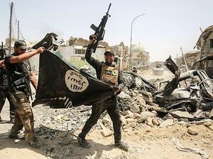 Members of the Iraqi Counter-Terrorism Service cheer in Mosul as they carry upside-down Islamic State flag, with the destroyed Al-Nuri mosque seen in the background on July 2, 2017 (AFP)