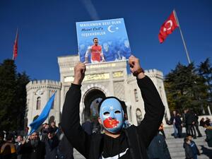 Uighur protesters in Istanbul hold pictures of Mesut Ozil (AFP)