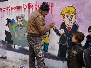 Anis Hamdoun, one of two Syrian painters who completed a mural on January 3, 2020 following the killing of Iranian Revolutionary Guards commander Qasem Soleimani puts the final touches on his creation in the town of Binnish in the northwestern Idlib province. AFP