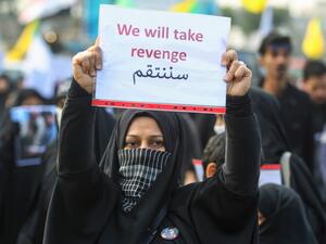 An Iraqi woman holds a placard during the funeral of Iranian military commander Qasem Soleimani, Iraqi paramilitary chief Abu Mahdi al-Muhandis and eight others in Baghdad's district of al-Jadriya, in Baghdad's high-security Green Zone, on January 4, 2020. (AFP/ File Photo)
