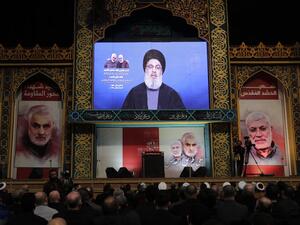 Supporters of the the Shiite Hezbollah movement watch as the movement's leader Hasan Nasrallah delivers a speech on a screen, in the Lebanese capital Beirut's southern suburbs on January 5, 2020. Nasrallah called on Iraq to free itself of the American "occupation" after top Iranian general Qasem Soleimani was killed in a US strike in Baghdad. ANWAR AMRO / AFP