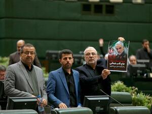 This handout picture provided by the Islamic Consultative Assembly News Agency (ICANA) shows an Iranian lawmaker holding a picture of slain top general Qasem Soleimani as he votes during a parliamentary session in Tehran.  (AFP/ File Photo)