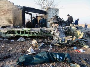People stand near the wreckage after a Ukrainian plane carrying 176 passengers crashed near Imam Khomeini airport in Tehran on January 8, 2020. All 176 people on board a Ukrainian passenger plane were killed when it crashed shortly after taking off from Tehran on January 8, Iranian state media reported. State news agency IRNA said 167 passengers and nine crew members were on board the aircraft operated by Ukraine International Airlines. Rouhollah VAHDATI / ISNA / AFP