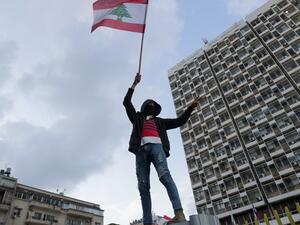 A Lebanese demonstrator waves the national flag during a demonstration outside the Electricite du Liban (Electricity Of Lebanon) national company headquarters in the Lebanese capital Beirut on January 11, 2020.(AFP/ File Photo)