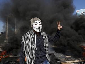 Lebanese anti-government protester flashes the victory sign in front of a burning roadblock during a demonstration in Beirut on January 14, 2020. (AFP/ File Photo)