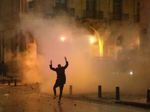 A Lebanese protester gestures at riot police guarding a road leading to parliament in central Beirut on January 19, 2020 amid ongoing anti-government demonstrations. PATRICK BAZ / AFP