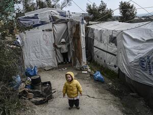A child stands at a makeshift camp next to the refugee camp of Moria, in the island of Lesbos on January 21, 2020. Greece's conservative government reinstated the migration ministry six months after scrapping it, amid frantic efforts to relocate thousands of asylum seekers from dismal island camps. ARIS MESSINIS / AFP