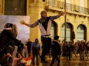 A Lebanese anti-government protester hurls stones at riot police during clashes in downtown Beirut on January 22, 2020. Lebanon's new prime minister claims to lead a government of technocrats but critics, including protesters, argue the line-up is window dressing for a set of ministers who are neither experts nor independent. PATRICK BAZ / AFP