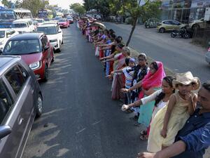 People line up along a road to form a 620 km human chain across the southern state of Kerala organized by the Left Democratic Front (LDF) to protest against the Indian government's Citizenship Amendment Act (CAA), in Kochi on January 26, 2020. STR / AFP