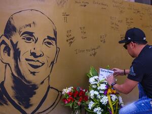 A fan places flowers to mourn former Los Angeles Lakers basketball player Kobe Bryant following his death overnight in the US, near the "House of Kobe" gym built in honour of his 2016 visit to the Philippines, in Manila on January 27, 2020. Maria TAN / AFP
