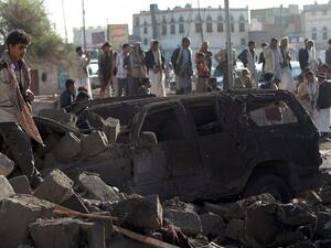 Yemenis stand at the site of a Saudi airstrike against Houthi rebels near Sanaa Airport on March 26, 2015, which killed at least 13 people. (photo credit: AFP/Mohammed Huwais)