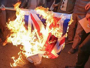 Iranian demonstrators set alight a Union Jack in front of the British embassy in Iran's capital Tehran today (AFP)