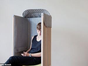 Upholstered in a soft, grey covering fabric, the chair provides a 'cosy, intimate, comfy and silent' space to isolate its occupants from the surrounding environment.