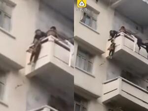 The pensioner hauls in the rope to pull up her grandson after he put the cat in a bag which he is carrying. The risky rescue operation reportedly took place on Sunday in Peng'an, China. (Video Screenshots)