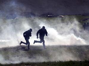 Palestinian protesters run for cover amid clashes with Israeli troops during a demonstration against a US brokered Middle East peace plan, near the West Bank village of Tamun near the Jordan Valley on January 31, 2020. AFP