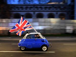 A man waves Union flags from a BMW Isetta as he drives past Brexit supporters gathering in Parliament Square, in central London on January 31, 2020, the day that the UK formally leaves the European Union. Britain on January 31 ends almost half a century of integration with its closest neighbours and leaves the European Union, starting a new -- but still uncertain -- chapter in its long history. DANIEL LEAL-OLIVAS / AFP