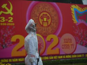 A policeman stands in front of a poster marking the 90th anniversary of the Communist Party of Vietnam in Hanoi on February 3, 2020. Vietnam suspends mainland China flights over virus fears as it spread to two dozen nations and killed 259 people in China where it originated in the city of Wuhan. Nhac NGUYEN / AFP