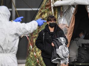 An Italian citizen (C) repatriated from the coronavirus hot-zone of Wuhan is directed to a health control zone after landing at the Mario De Bernardi military airport in Pratica di Mare, south of Rome, on February 3, 2020 prior to be placed in quarantine at the nearby Cecchignola center. ANSA / AFP