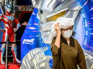 A woman wearing a protective facemask walks outside a shopping mall Mladen ANTONOV / AFP