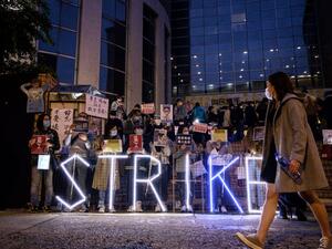 A light installation reading "strike" stands before striking members of the Hospital Authority Employees Alliance (HAEA) and other activists at the Hospital Authority building in Hong Kong on February 7, 2020. AFP
