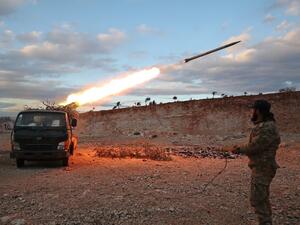 A Syrian rebel fighter fires a Grad rocket towards government forces in northwestern Syria on February 8, 2020. Since December, government forces have pressed a blistering assault against the Idlib region with Russian support, retaking town after town despite warnings from rebel ally Turkey to back off. Omar HAJ KADOUR / AFPq