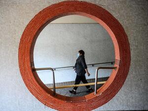 A resident wearing a face mask walks outside Hong Mei House at the Cheung Hong Estate in Hong Kong on February 11, 2020, following the evacuation of more than 100 people from the housing block after four residents in two different apartments tested positive for the new coronavirus. Officials said the relocation of residents in Tsing Yi district was a precautionary measure after three members of the same family contracted the virus. Anthony WALLACE / AFP