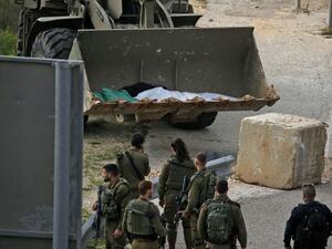Israeli soldiers retrieve the body of a Palestinian in the village of Ras Karkar, near Ramallah in the occupied West Bank on February 17, 2020, reported to be the body of a man who wounded an Israeli soldier in a shooting attack ten days ago. ABBAS MOMANI / AFP