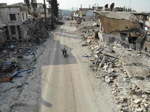 An aerial view taken on February 19, 2020 shows a man riding his motorcycle through destroyed buildings in the Syrian town of Ihsim in the southern countryside of Idlib. Omar HAJ KADOUR / AFP