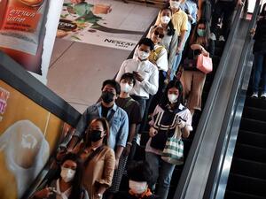 This photo taken on February 18, 2020 shows people wearing protective facemasks, amid concerns of the COVID-19 coronavirus outbreak, as they ride on an escalator during the morning commute in Bangkok. Lillian SUWANRUMPHA / AFP