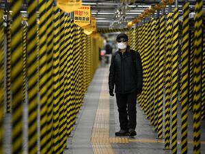 A man wearing a face mask walks between columns at a subway station being renovated in Seoul on February 22, 2020. AFP