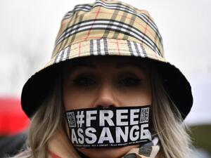 A supporter of WikiLeaks founder Julian Assange wearing tape on her mouth calling for his freedom  (AFP)