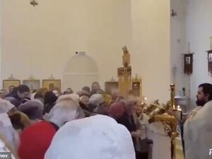 A Russian priest has been caught on camera hilariously spraying worshippers with holy water. (Video Screenshot)