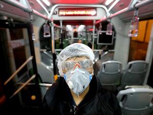 A Tehran Municipality worker cleans a bus to avoid the spread of the COVID-19 illness on February 26, 2020. Iran said Tuesday its coronavirus outbreak, the deadliest outside China, had claimed 15 lives and infected nearly 100 others -- including the country's deputy health minister. The Islamic republic's neighbours have imposed travel restrictions and strict quarantine measures after reporting their first cases in recent days, mostly in people with links to Iran. ATTA KENARE / AFP