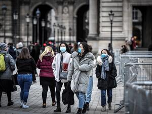 Tourists wearing a protective face mask amid fears of the spread of the COVID-19 novel coronavirus walk at the Pyramide du louvre area on February 28, 2020 in Paris. STEPHANE DE SAKUTIN / AFP