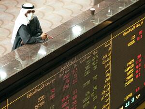 A Kuwaiti trader wearing a protective mask follows the market at the Boursa Kuwait stock exchange in Kuwait City on March 1, 2020. AFP