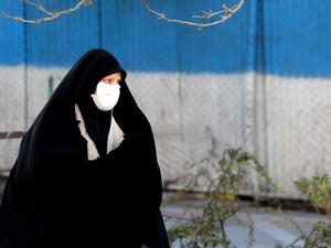 An Iranian woman wearing a protective mask crosses a road in Tehran on March 2, 2020, following the COVID-19 illness outbreak, which Iran says has claimed 66 lives out of 1,501 cases of infection in the Islamic republic since February. The novel coronavirus has sparked intense debate in Iran between ultra-conservative Shiite clerics and the government on how to most effectively tackle the deadliest outbreak of the disease outside China. ATTA KENARE / AFP