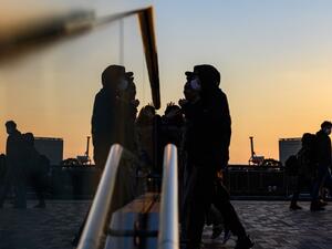 People wearing face masks walk at the Odaiba Seaside Park in Tokyo on March 6, 2020. Construction of all new permanent venues for the Tokyo 2020 Olympics and Paralympics is now complete, organisers said on March 6, as preparations continue despite worries over the COVID-19 coronavirus outbreak. Philip FONG / AFP