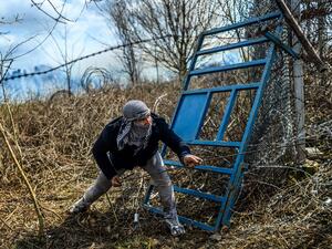 A migrant tries to breack fences near the Pazarkule crossing gate of the Turkey-Greece border on March 7, 2020 in the province of Edirne where makeshift camps have sprung up around the border as thousands of refugees have been encouraged by Turkey to leave for the European Union, in a bid to gain Western backing in Syria. AFP/File