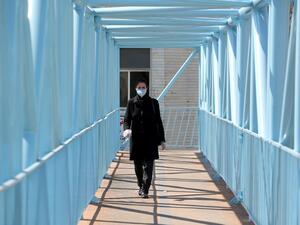 An Iranian pedestrian walks while wearing a protective mask in Tehran on March 10, 2020 amid the spread of coronavirus in the country. Iran today reported 54 new deaths from the novel coronavirus in the past 24 hours, the highest single-day toll since the start of the country's outbreak.  ATTA KENARE / AFP