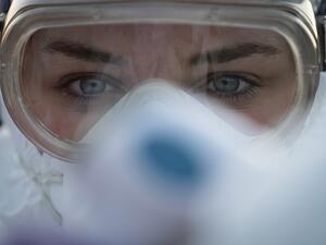 A medical worker wears protective goggles as she prepares to measure motorists' body temperatures at the Slovenian-Italian border crossing near Nova Gorica, on March 11, 2020, after Slovenia's government announced it would close its border with Italy, hard hit by the outbreak of COVID-19, the new coronavirus. Italy's neighbours Austria and Slovenia announced on March 10 Tuesday strict travel restrictions and other measures in the wake of similar moves by Rome to limit the spread of the new coronavirus. Jure