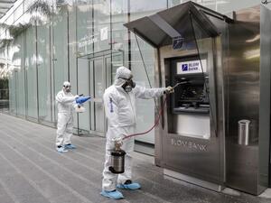 Employees of a private company spray sanitising liquid around a bank in a bid to limit the spread of the cornonavirus Civid-19, in the Lebanese capital Beirut on March 15, 2020. ANWAR AMRO / AFP