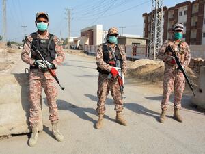 Soldiers wearing facemasks stand guard on road leading to a quarantine faciltity (R) for people returning from Iran via the Pakistan-Iran border town of Taftan to prevent the spread the COVID-19 coronavirus, in Sukkur in southern Sindh province on March 17, 2020. Shahid ALI / AFP