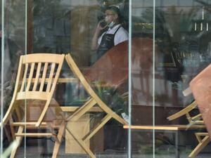 A picture taken March 18, 2020 shows a waiter speaking on his mobile phone inside a closed cafe in Riyadh amid measures to contain the novel COVID-19 coronavirus disease in the desert kingdom. Saudi Arabia called today for a 'virtual' G20 summit over coronavirus. FAYEZ NURELDINE / AFP