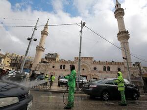 Amman municipality workers spray cars with sanitisers in the Jordanian capital on March 18, 2020 amidst measures to fight the spread of the coronavirus COVID-19. Khalil MAZRAAWI / AFP