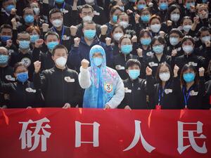 Members of a medical assistance team from Jiangsu province chant slogans at a ceremony marking their departure after helping with the COVID-19 coronavirus recovery effort, in Wuhan, in China's central Hubei province on March 19, 2020. Medical teams from across China began leaving Wuhan this week after the number of new coronavirus infections dropped. China on March 19 reported no new domestic cases of the coronavirus for the first time since it started recording them in January, but recorded a spike in infe